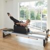 Pilates instructor using sitting box on Pilates reformer