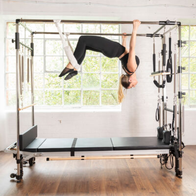 Woman using Align-Pilates C8-Pro Pilates Reformer with Full Cadillac
