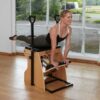 Pilates instructor performing chair exercise on combo chair 3