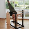 Pilates instructor performing an inverted ladder barrel exercise