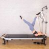 C Series Pilates reformer in use with half cad