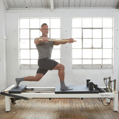 man using pilates reformer and maple pole