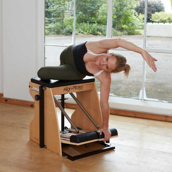 Pilates instructor performing chair exercise on combo chair 3