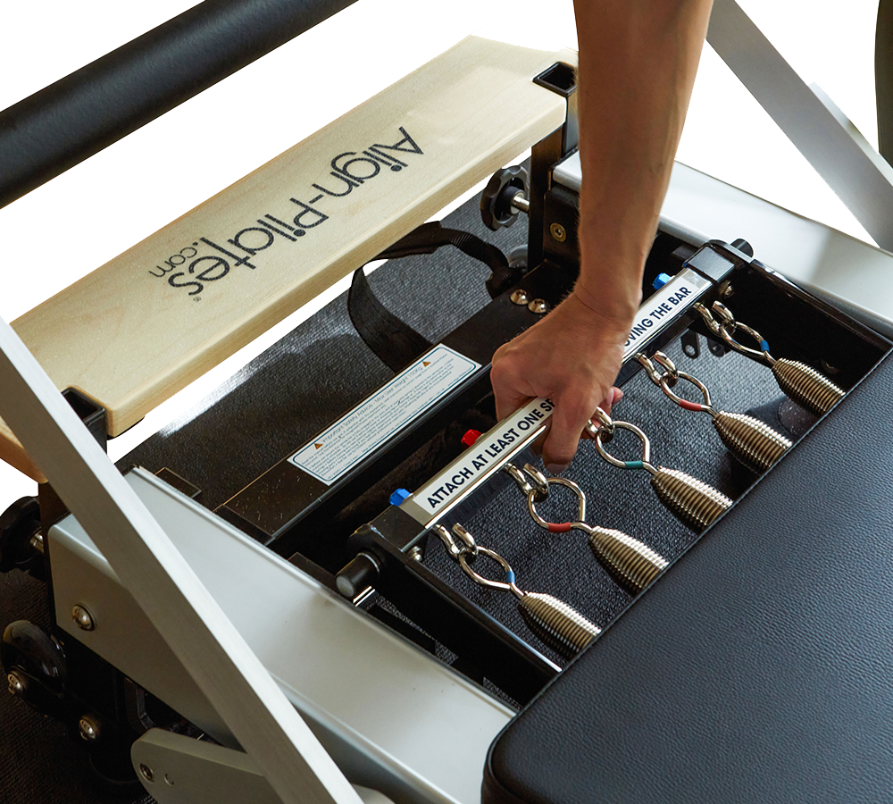 Pilates instructor changing the spring bar on the Pilates reformer