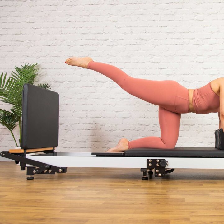 Pilates instructor on F3 Foldable Pilates Reformer using the jump board