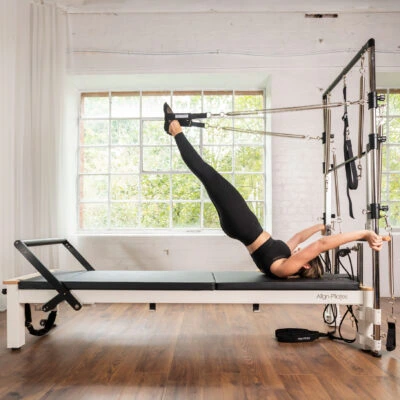 Woman exercising on Align-Pilates C8-S Pro Pilates Reformer with Half Cadillac